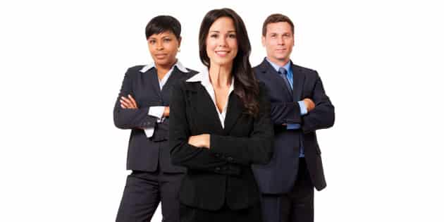 Three professionals in business attire standing confidently with arms crossed.