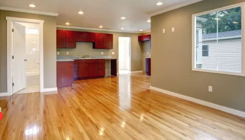 Spacious room with polished hardwood floors, cherry wood cabinets, and natural lighting.