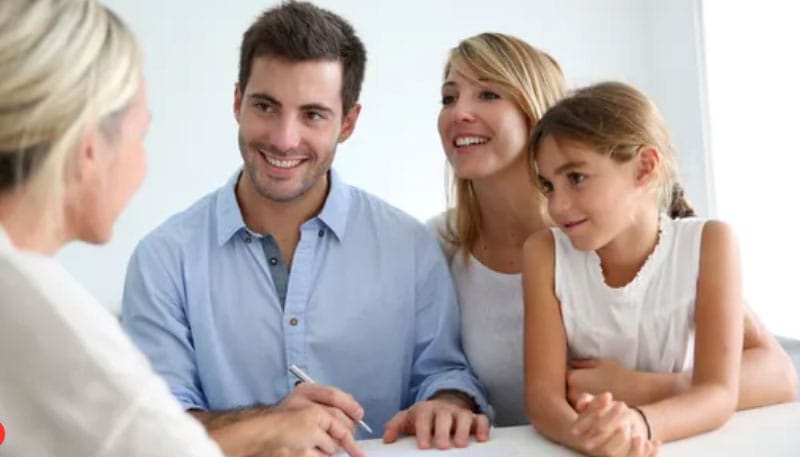 A family with a young child interviewing a female real estate agent.