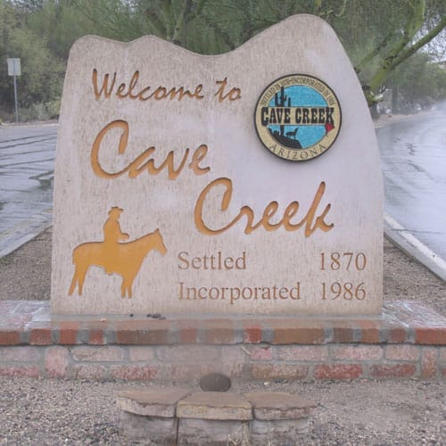 Welcome sign for cave creek, arizona, on a rainy day.